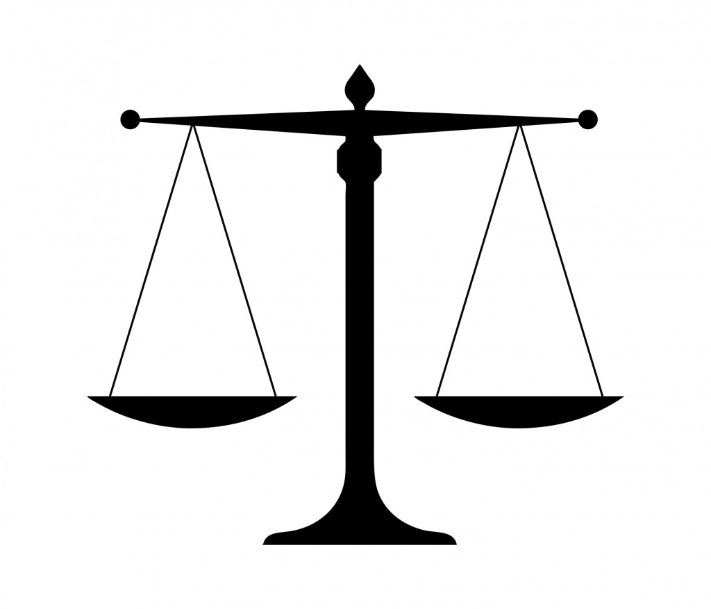 Black silhouette of balanced scales of justice on a white background